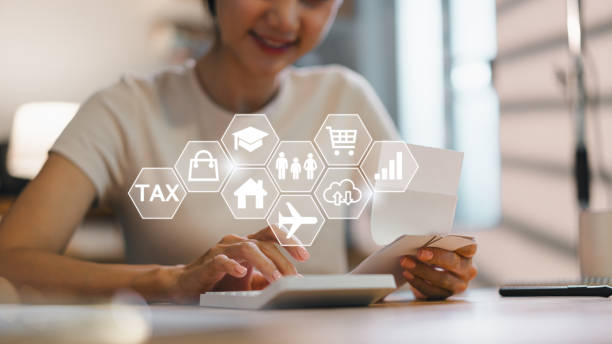 istock woman is managing her finances while using calculator and reviewing documents, showcasing focus on budgeting and planning. scene conveys sense of organization and responsibility 2185537949