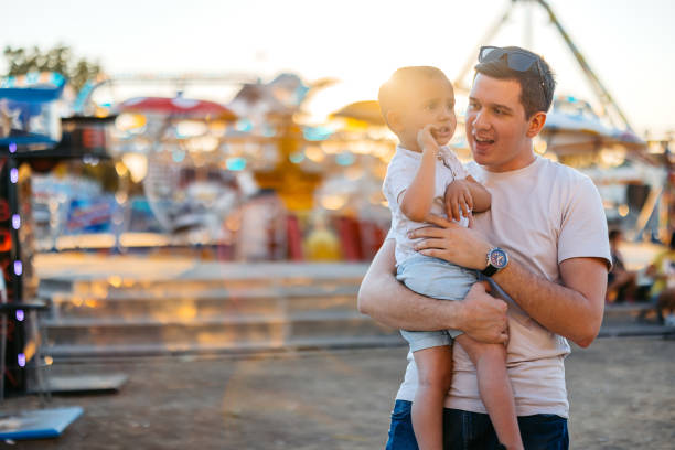 istock Young Father Holding His Son In An Amusement Park 2185537966