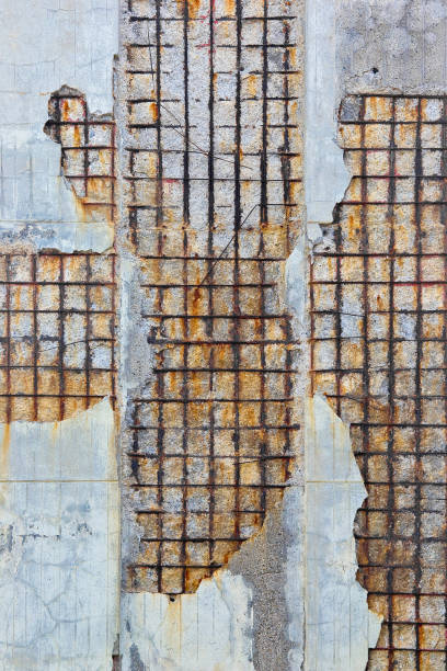 istock Damaged concrete wall without protective concrete cover - Corroded and oxidized reinforcing bars - Concrete fragments dangerously detach from the concrete mass 2185538063
