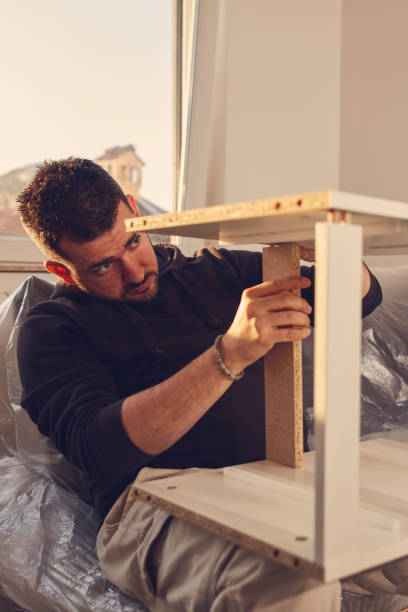 istock Man working and assembling furniture in a new apartment. 2185538632