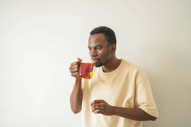 istock Young black man with tooth sensitivity drinks hot tea waiting for it to cool down 2185539118