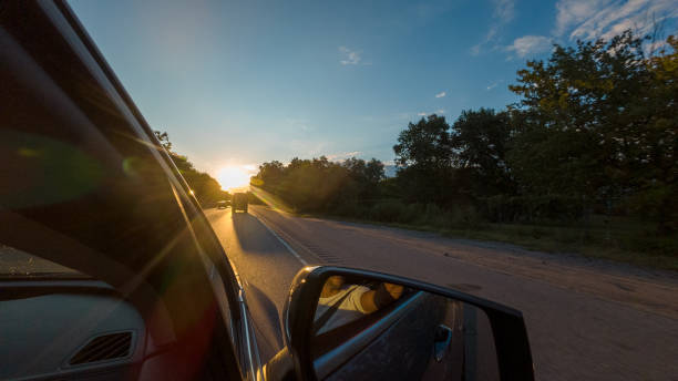 istock A car is driving down a road with a beautiful sunset in the background 2185539869