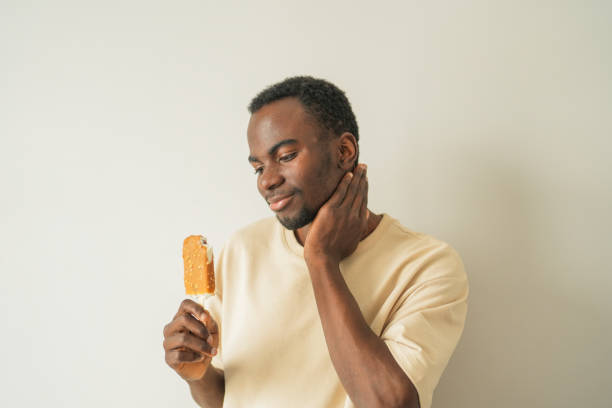 istock Young black man with tooth sensitivity has toothache after biting ice cream. 2185542074