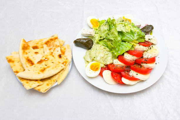 Caprese salad with Romaine lettuce, hard boiled eggs, stuffed vine leaves and flatbread.