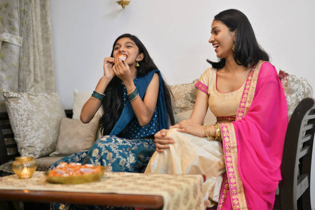 istock Sisters sharing the joy of Diwali sweets at home 2185546149