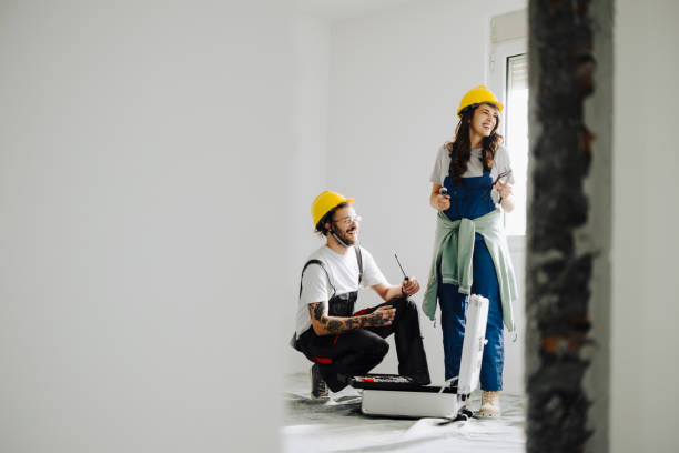 istock Female and Male Construction Workers Working Together on an Apartment Renovation, Kneeling near Toolbox 2185548865