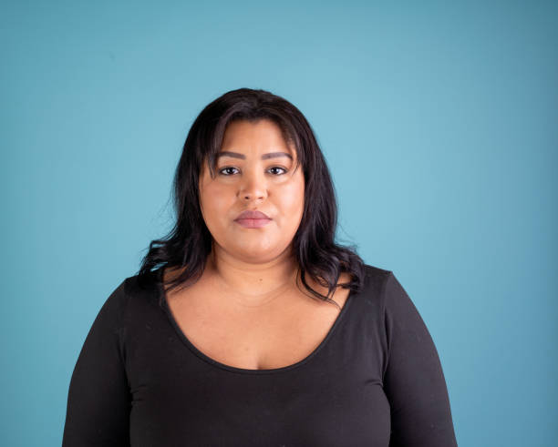 istock Hispanic woman looking at the camera with blank stare 2185548976