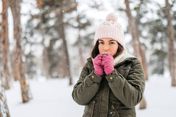 istock Young Woman Feeling Cold In A Snowy Forest 2185550022