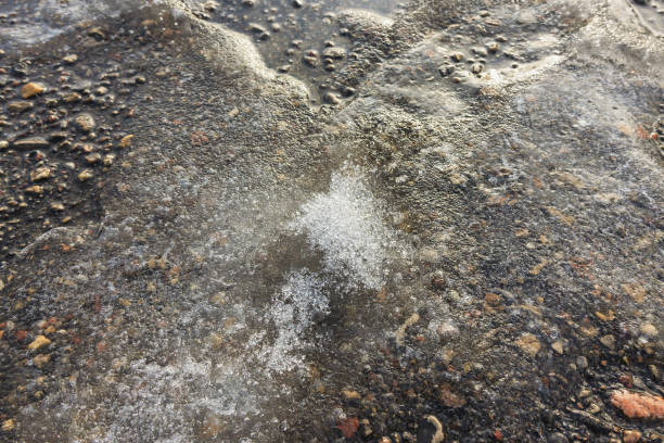 istock Endless melted snow and ice on the asphalt surface in spring under the bright sun 2185551889