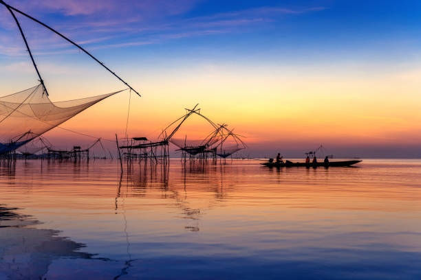 Beautiful sunrise and fishing dip nets at Pakpra in Phatthalung, Thailand. stock photo