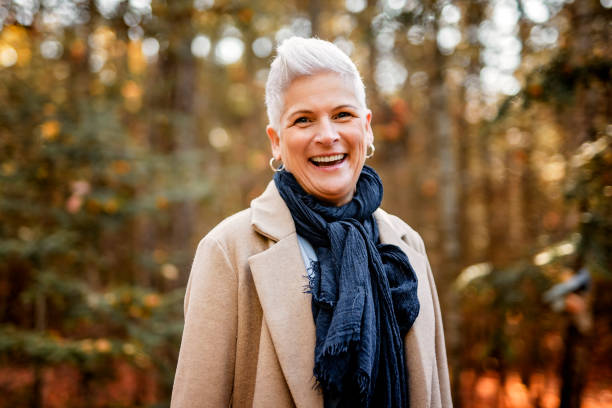 istock Mature woman in autumn forest, dressed in cozy fall attire, Reflection and connection with nature, wellness 2185568749