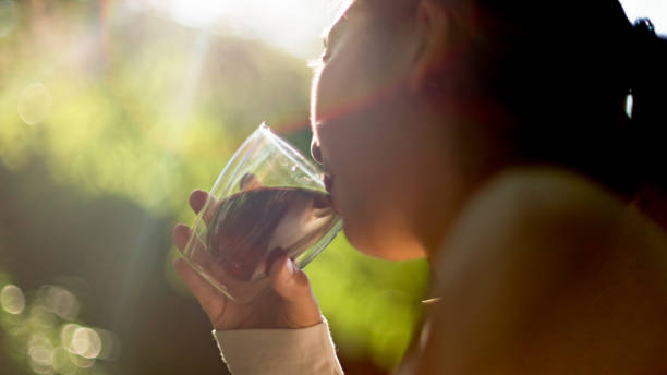Close-up of woman sipping coffee or tea among nature.