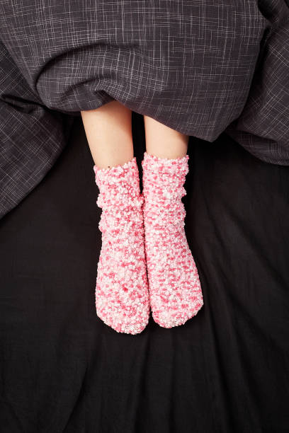 istock Woman with pink woollen socks in Bed 2185571873