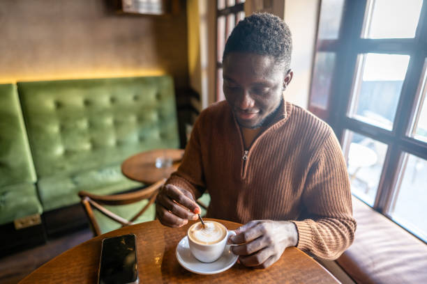 istock Afro-american man drinking coffee in cafe 2185574591