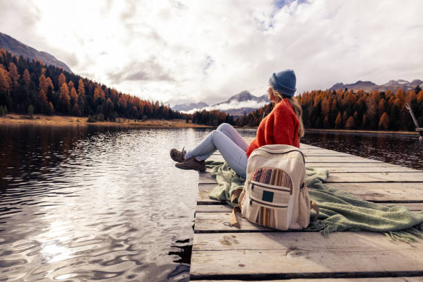 istock Woman Relaxing on a Dock by a Scenic Mountain Lake 2185576166