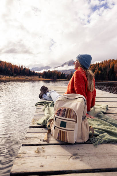 istock Woman Relaxing on a Dock by a Scenic Mountain Lake 2185576168