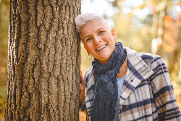 istock Mature woman in autumn forest, dressed in cozy fall attire, Reflection and connection with nature, wellness 2185578100