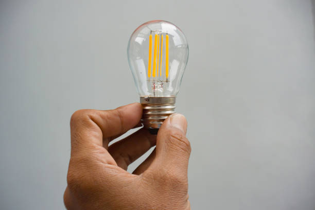 istock Hand holding a traditional single bulb lamp 2185580593