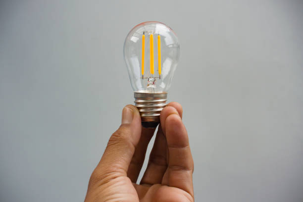 istock Hand holding a traditional single bulb lamp 2185580603