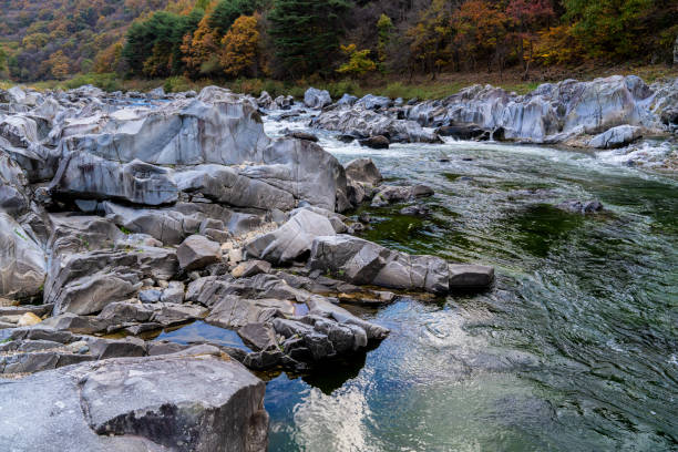istock rocks and flowing stream in the autumn valley 2185581521