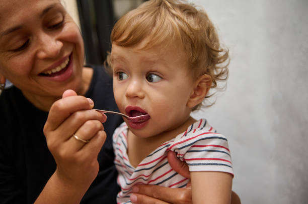 istock Mother feeding her toddler boy with a spoon indoors 2185582206