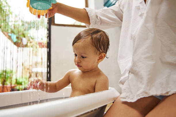 istock Mother bathing baby in a home setting with natural light 2185582322