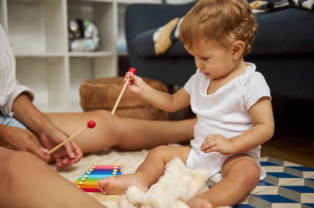 istock Baby playing with colorful xylophone in a cozy home setting 2185582415