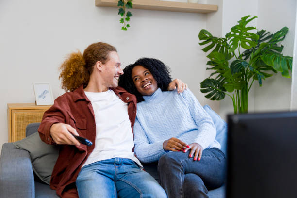 istock Happy couple watching television and relaxing on sofa at home 2185582667