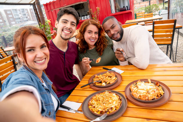 istock Group of friends smiling while taking a selfie at a restaurant 2185584051