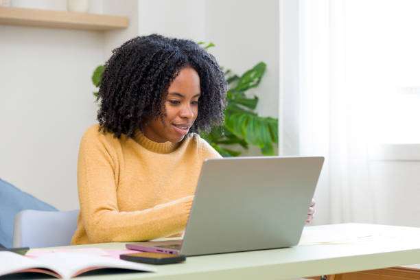 istock Young black woman working from home using laptop 2185584232