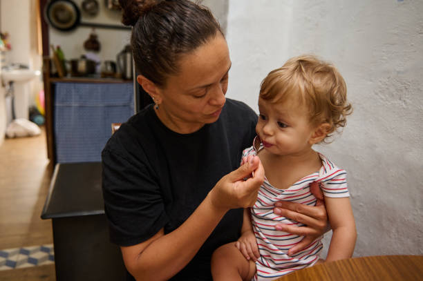 istock Mother feeding toddler at home in intimate kitchen setting 2185584426