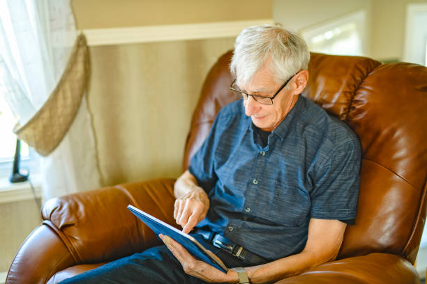 istock Portrait of retired senior man standing at home using tablet 2185584637