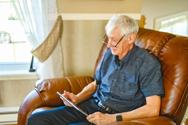 istock Portrait of retired senior man standing at home using tablet 2185584639