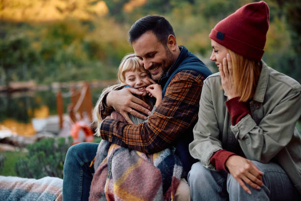 istock Affectionate father embracing his daughter during family camping in nature. 2185584987