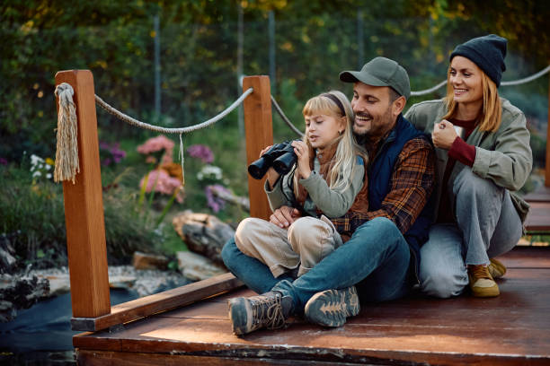 istock Little girl using binoculars while exploring the nature with her parents. 2185585146