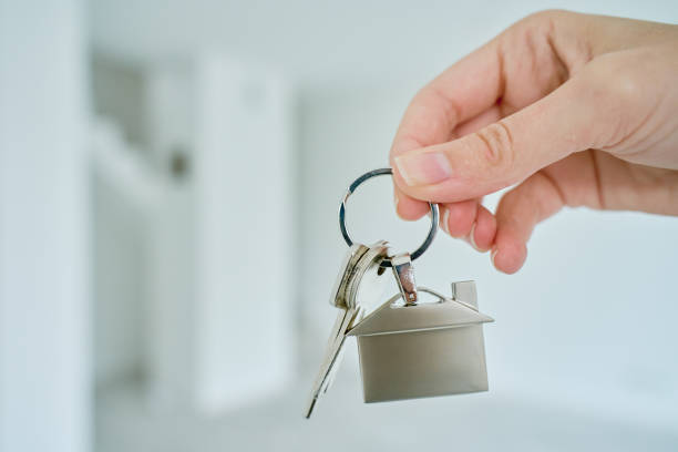 istock Hand holds house keys against new apartment 2185587470