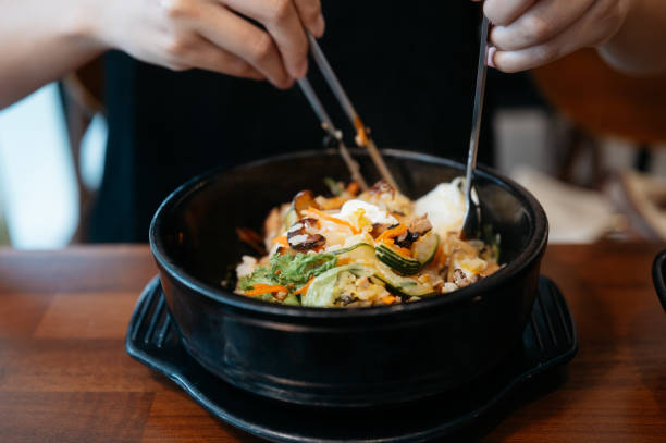 Woman eating bibimbap in Korean restaurant