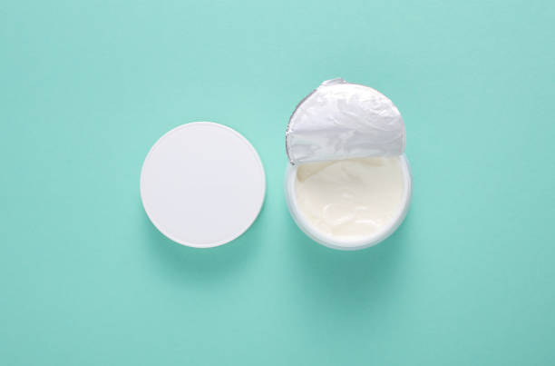 istock White open cream jar on mint green background. Top view 2185588826