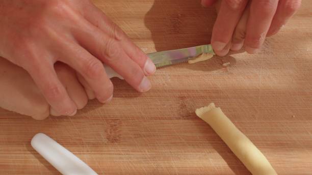 istock A person is cutting handmade pasta with a round shape is called orecchiette. 2185589283