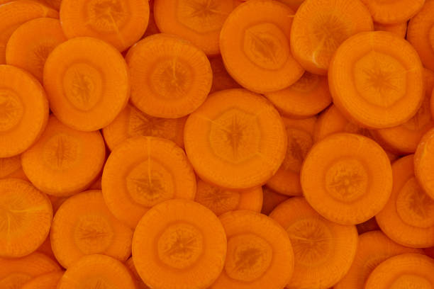 istock Slices of fresh ripe carrot as background, top view 2185592709