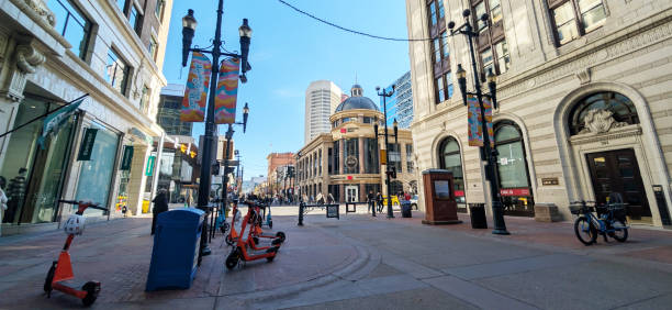 Calgary, Canada - October 24, 2024: Looking east on the 300-block of 8th Avenue Southwest. The National Bank Financial with a dome stands on the 200-block of 8th Avenue Southwest. Bankers Hall stands to the right. Pedestrians walk along segments of a car-free zone downtown.