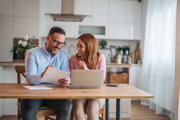 istock A married business couple in the kitchen using a laptop at the table. 2185596543