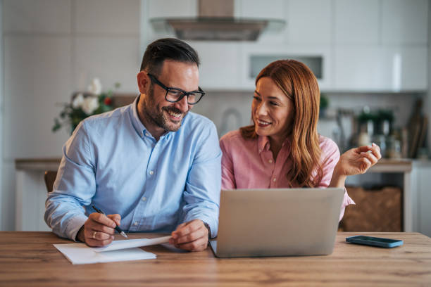 istock A married business couple in the kitchen using a laptop at the table. 2185596561
