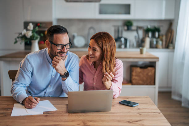 istock A married business couple in the kitchen using a laptop at the table. 2185597455