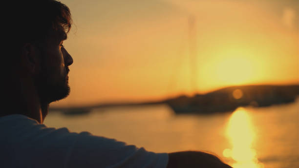 istock Man Relaxing by the Sea at Sunset 2185597634