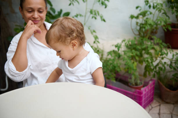 istock Mother and child sitting at a table in a garden setting 2185597984