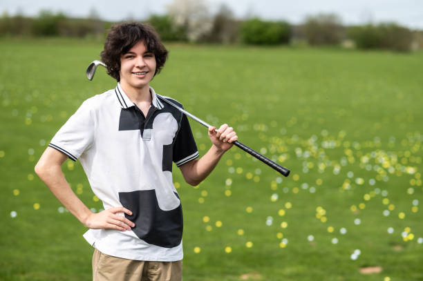 Young golfer. Young golfer standing on a gold cart and looking confident