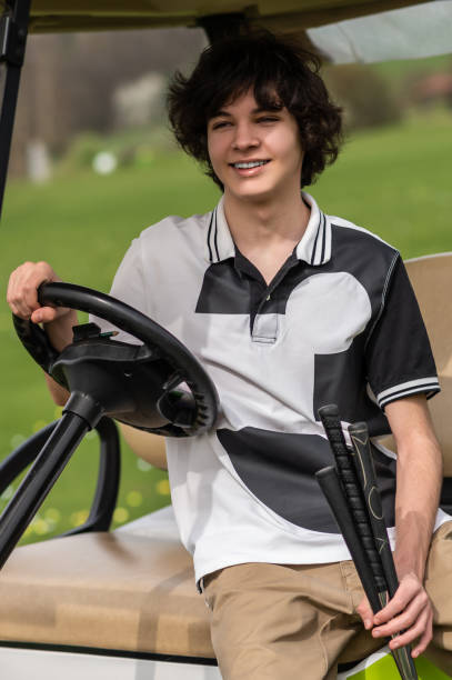 istock Handsome young golfer riding a gold cart and looking contented 2185599481