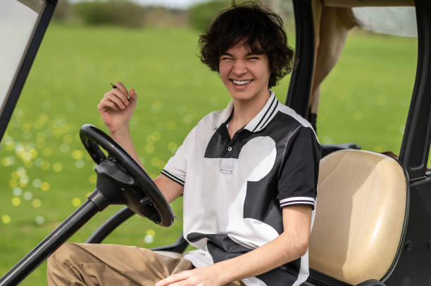 istock Handsome young golfer riding a gold cart and looking contented 2185599484