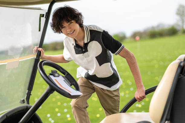 istock Young golfer getting in a golf cart and looking determined 2185599486